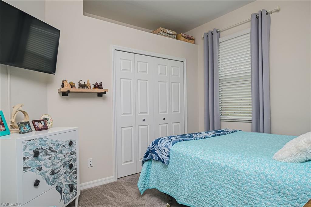 1803 Alameda Drive Naples, FL 34120 - Photo 14 of 30 a bedroom with a bed and a flat screen tv