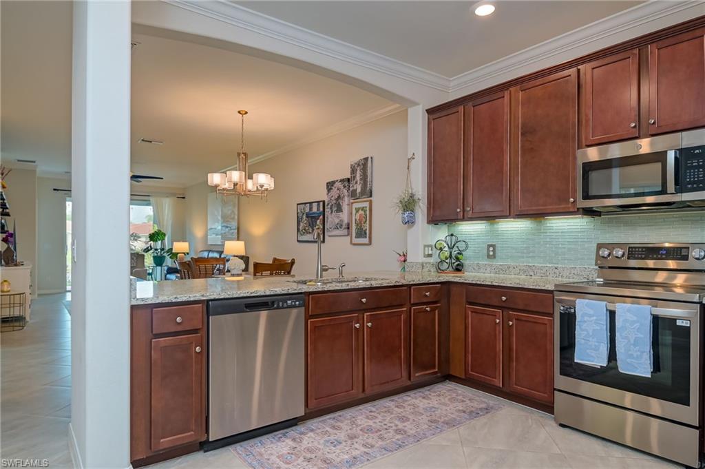 1803 Alameda Drive Naples, FL 34120 - Photo 9 of 30 a kitchen with stainless steel appliances granite countertop wooden cabinets a sink and dishwasher