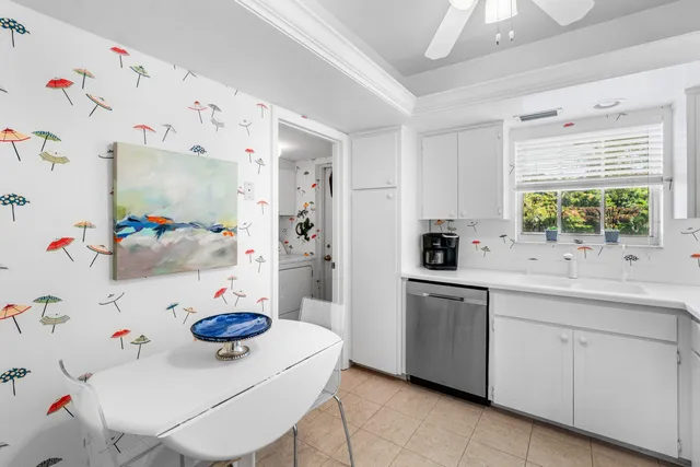 a kitchen with a sink a stove and white cabinets