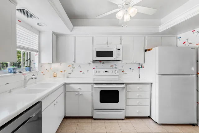 a kitchen with white cabinets sink and white appliances