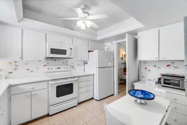 a kitchen with white cabinets and white appliances
