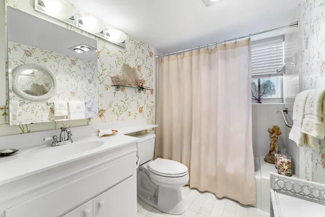 a bathroom with a sink a toilet and shower curtain