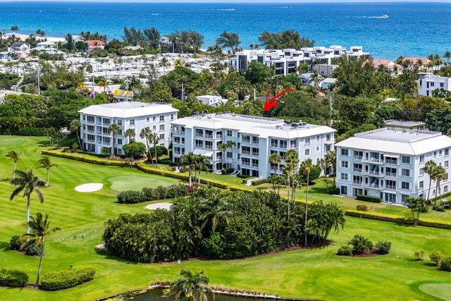 an aerial view of a house with a garden and lake view