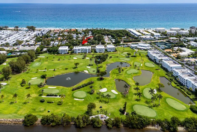 an aerial view of residential houses with yard and ocean view
