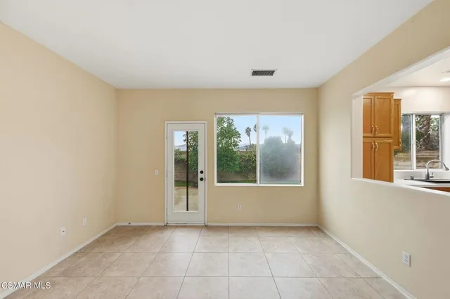 an empty room with entrance and windows