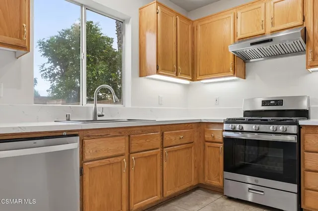 a kitchen with stainless steel appliances granite countertop a sink a stove and a microwave