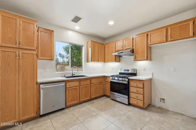 a kitchen with stainless steel appliances granite countertop a stove sink and cabinets