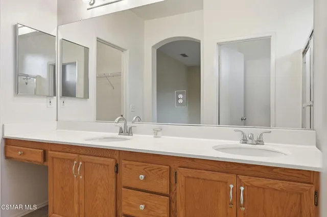a bathroom with a granite countertop sink double and mirror