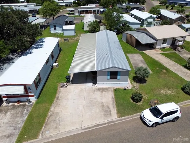 an aerial view of a house with swimming pool patio and yard