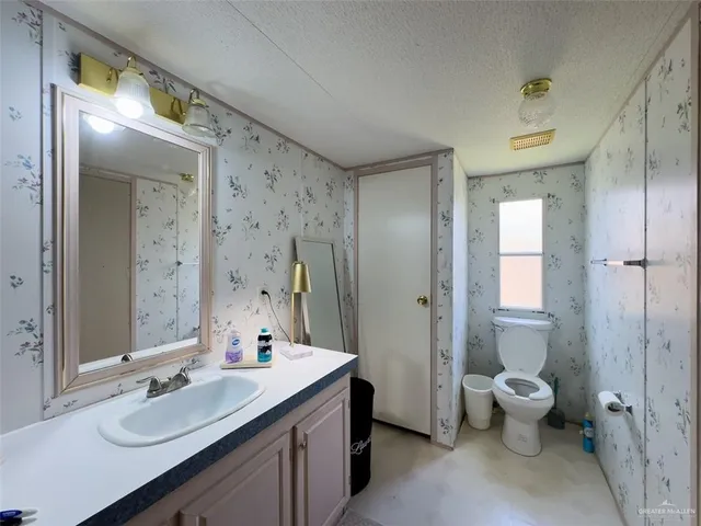 a bathroom with a double vanity sink mirror and toilet