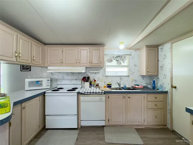 a kitchen with stainless steel appliances kitchen island granite countertop a stove and white cabinets