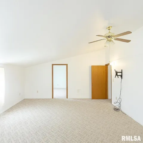 an empty room with closet and fan