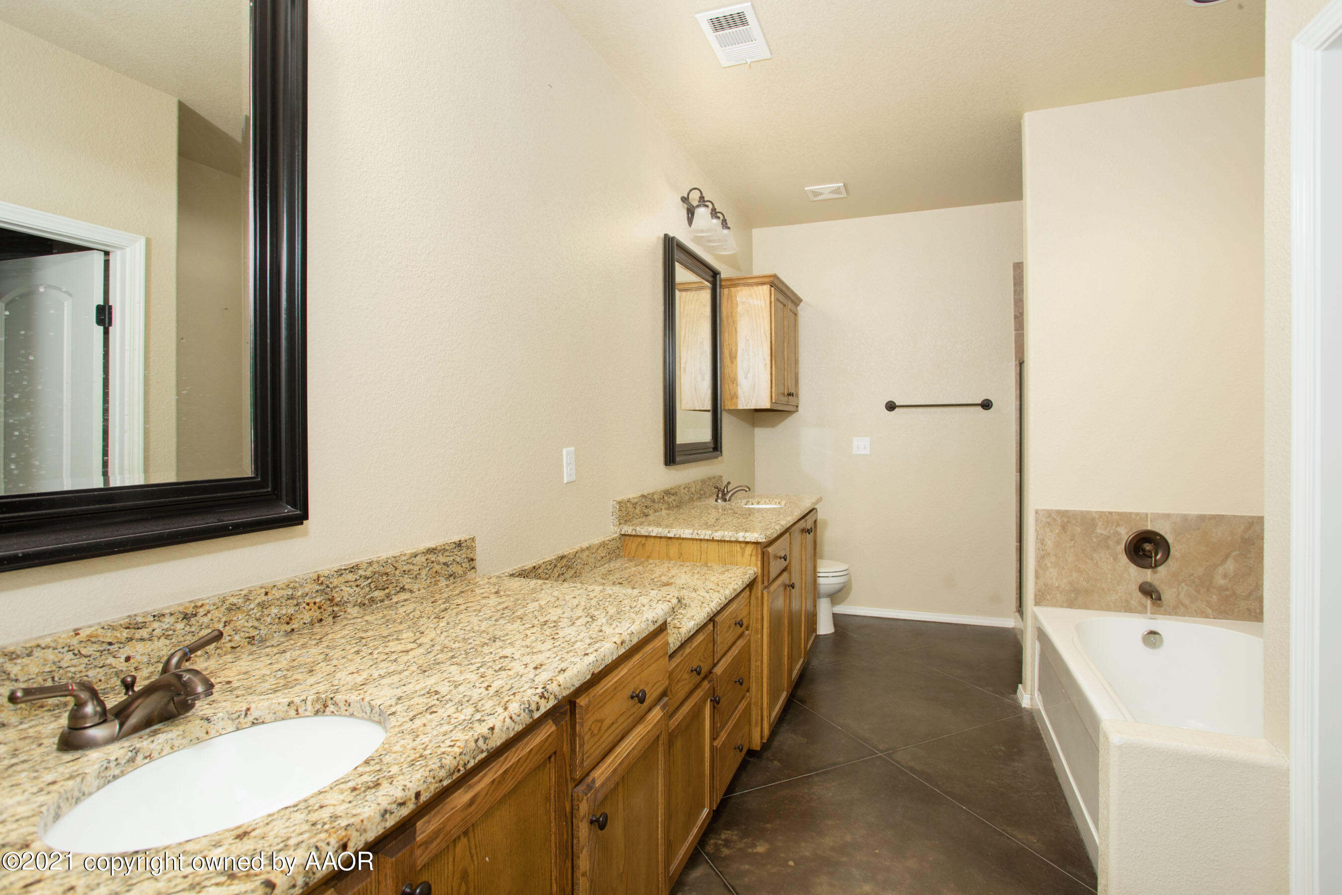 9907 Asher Avenue Amarillo, TX 79119 - Photo 13 of 24 a spacious bathroom with a granite countertop double vanity sink a mirror and a bathtub