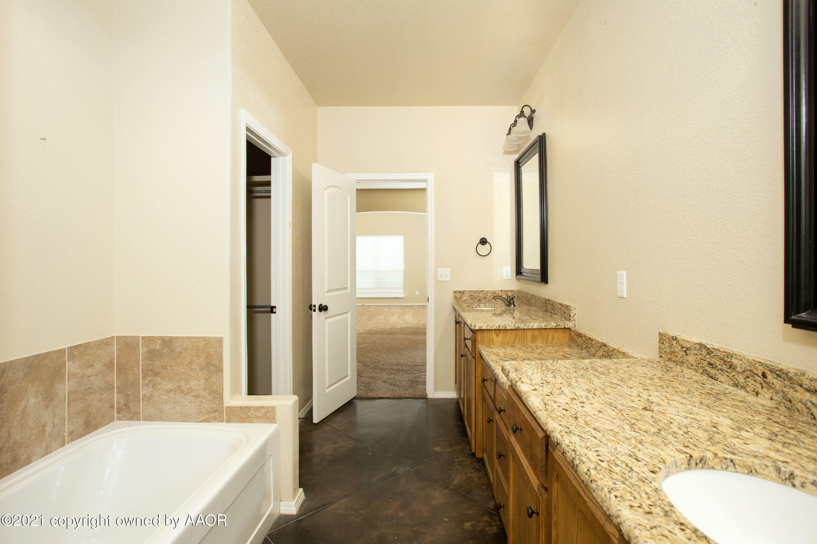 9907 Asher Avenue Amarillo, TX 79119 - Photo 15 of 24 a bathroom with a granite countertop tub sink and mirror
