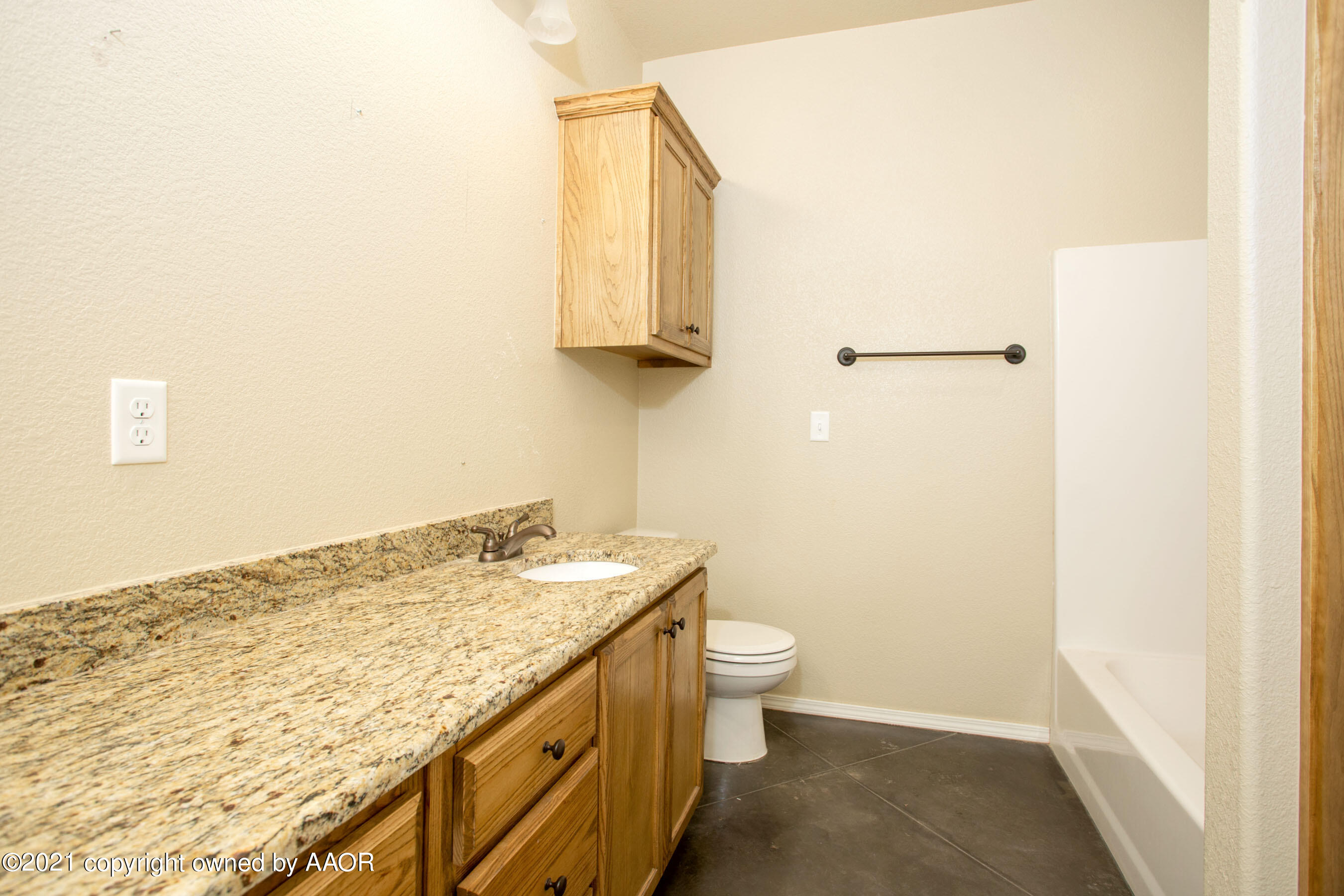 9907 Asher Avenue Amarillo, TX 79119 - Photo 19 of 24 a bathroom with a granite countertop sink a toilet and mirror