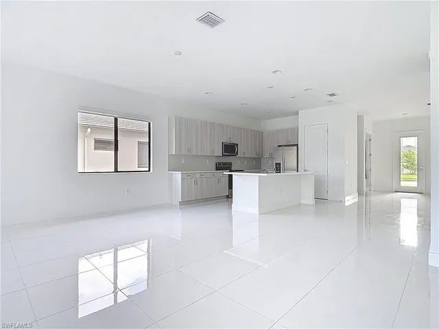 a large white kitchen with cabinets and a couch