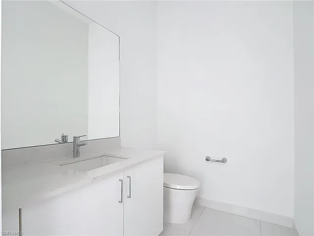 a bathroom with a granite countertop sink a toilet and a mirror