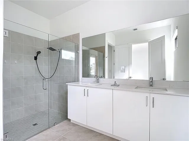 a bathroom with a granite countertop sink a mirror and a shower