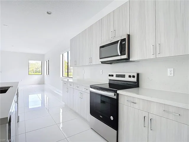 a kitchen with stainless steel appliances granite countertop a stove a sink and a microwave