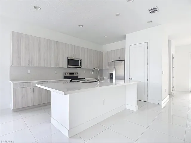a kitchen with stainless steel appliances a sink stove and cabinets