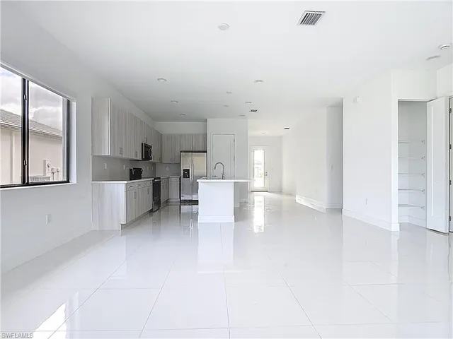 a view of kitchen with furniture and refrigerator