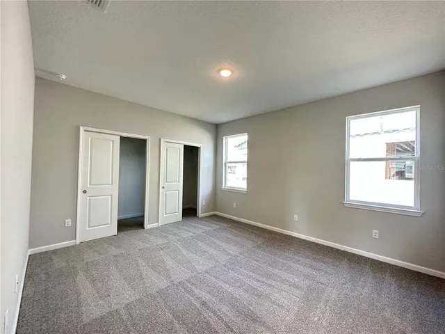 an empty room with windows and closet
