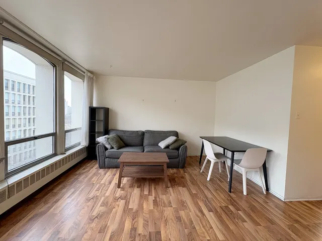 a living room with furniture and a wooden floor