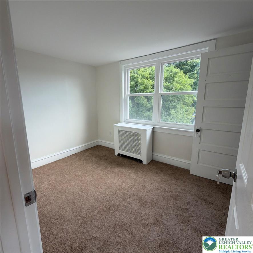 5111 Vera Cruz Road Emmaus, PA 18049 - Photo 35 of 44 Plush carpeting and classic radiator covers define this inviting bedroom space.