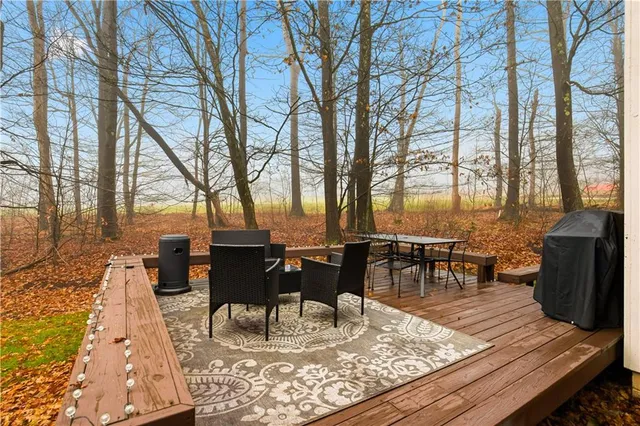a view of a wooden chairs and fire pit in the backyard