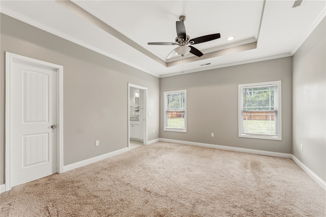 1411 Dunn Road Anderson, SC 29625 - Photo 16 of 30 This spacious bedroom offers a tranquil retreat with a ceiling fan and plush carpeting.