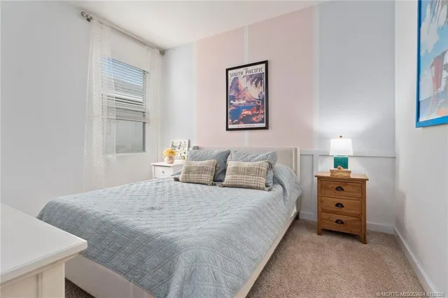 a bedroom with a bed and a lamp on dresser