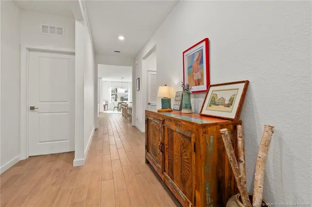 a view of a hallway with wooden floor and stairs