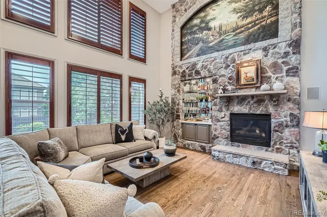 a living room with furniture a fireplace a rug and a large window