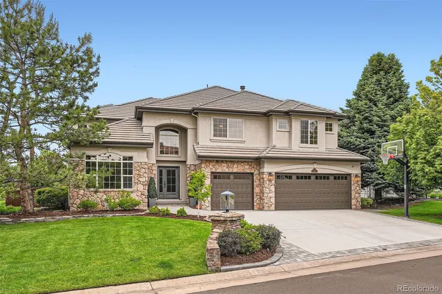 a front view of a house with a garden and plants