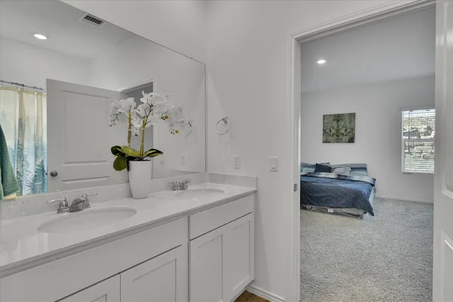 a en suite bathroom with a double sink and mirror
