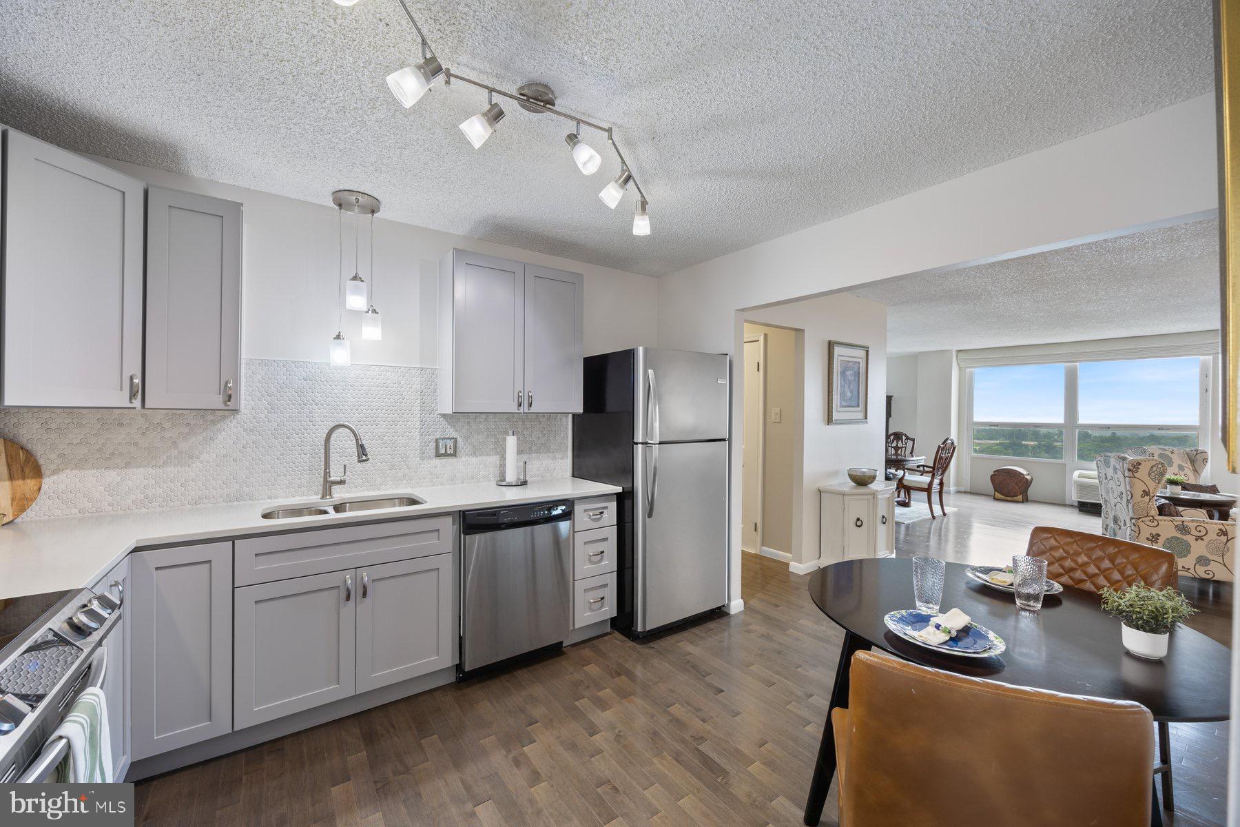 a kitchen with stainless steel appliances granite countertop a sink dishwasher stove refrigerator and cabinets