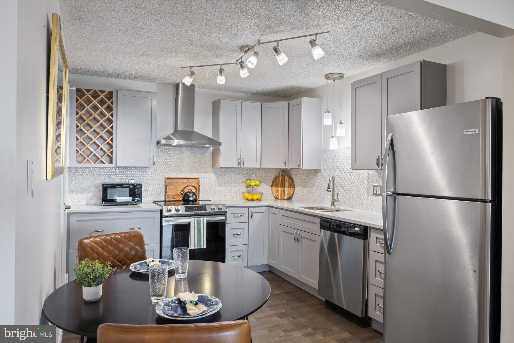 205 East Joppa Road, Unit 2403 Towson, MD 21286 - Photo 13 of 48 a kitchen with stainless steel appliances granite countertop a refrigerator a stove a sink dishwasher and white cabinets with wooden floor
