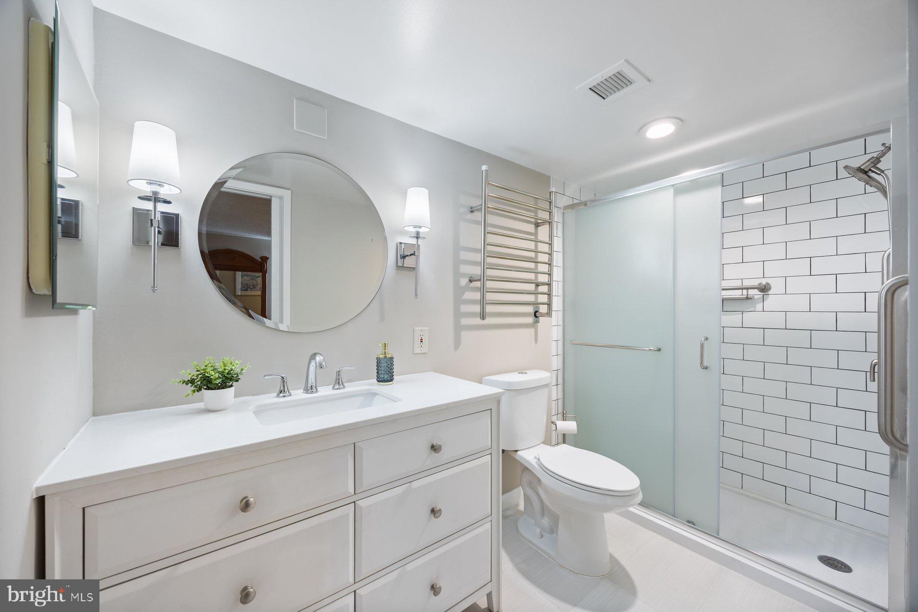 205 East Joppa Road, Unit 2403 Towson, MD 21286 - Photo 24 of 48 a bathroom with a toilet a sink a mirror a glass door and shower