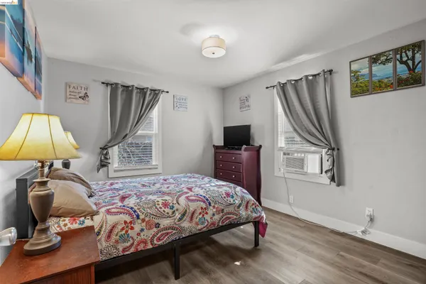 a bedroom with a bed and a flat tv screen on the dresser
