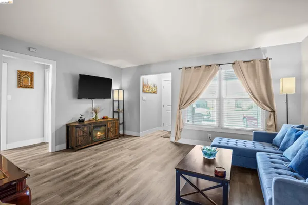 a living room with furniture a flat screen tv and a large window