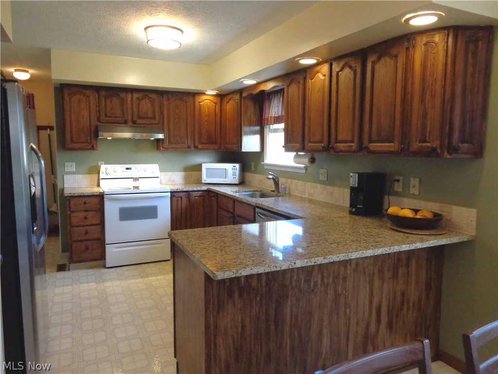 14214 Kneisel Road Vermilion, OH 44089 - Photo 4 of 24 View #1 of the kitchen w/granite counter tops, range & refrigerator stay, lots of cabinet space.