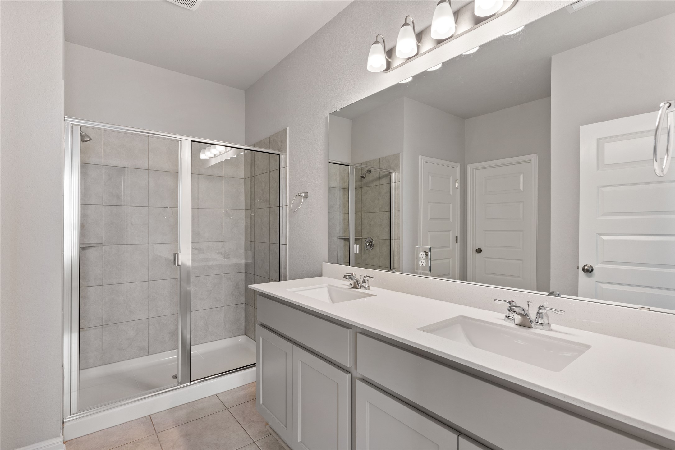 313 Mclintock Road Jarrell, TX 76537 - Photo 15 of 17 A well-lit primary bathroom features a double vanity and a glass-enclosed shower.