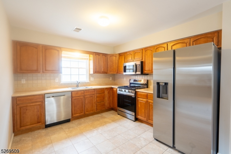 a modern kitchen with stainless steel appliances granite countertop a refrigerator and a sink