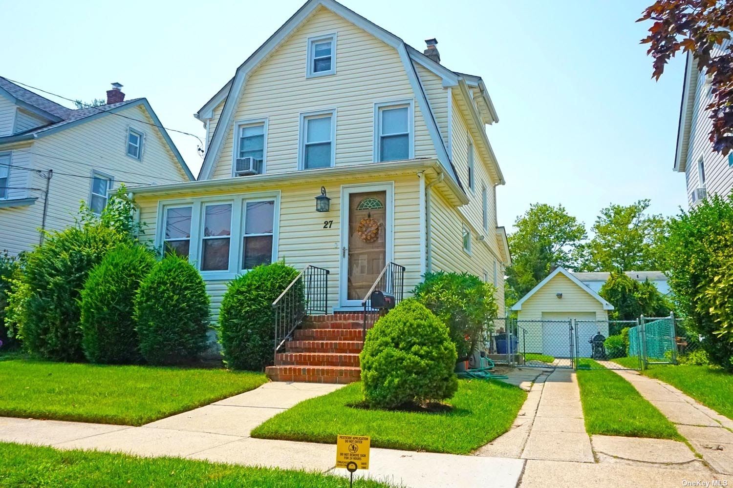 a front view of a house with a yard and trees