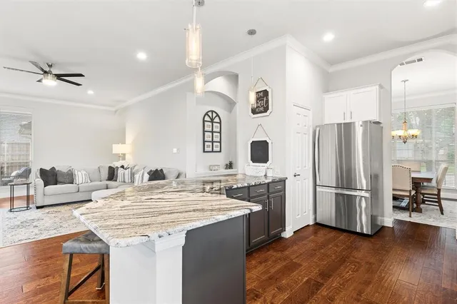 a kitchen with stainless steel appliances kitchen island granite countertop a refrigerator and a stove top oven