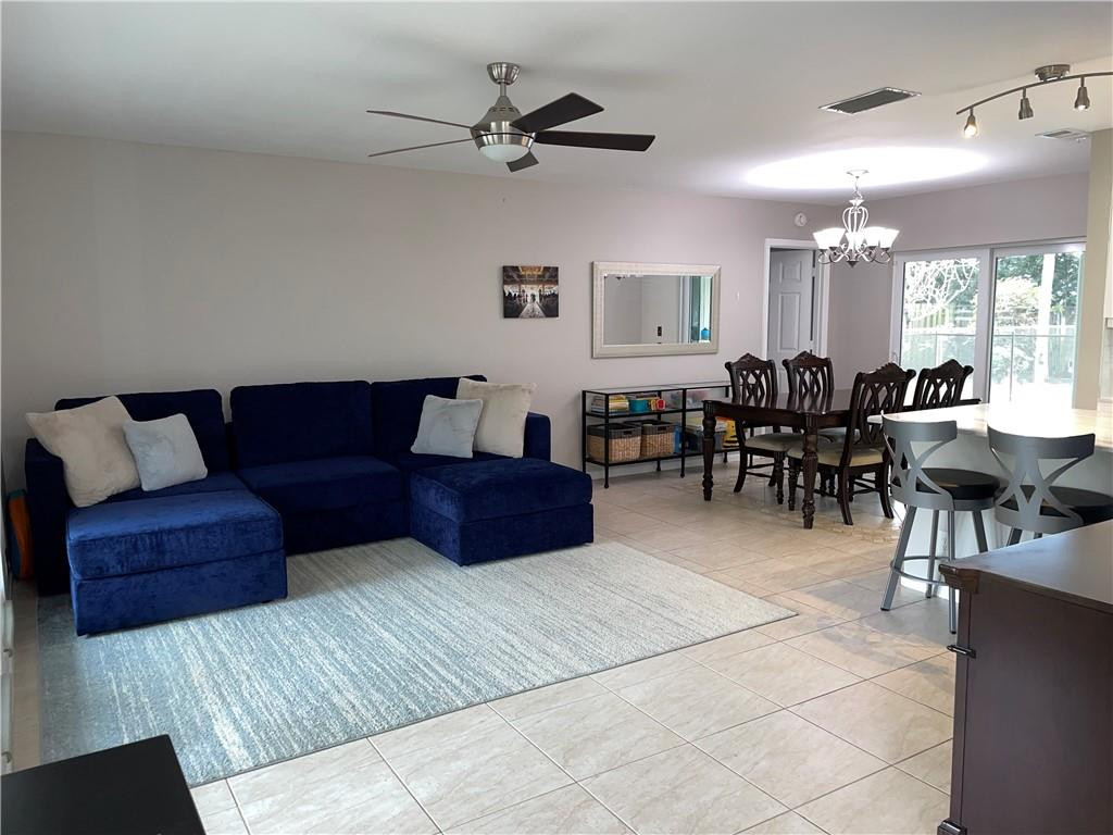 2358 Northwest 31st Street Boca Raton, FL 33431 - Photo 2 of 11 a living room with furniture a two couches and a dining table with wooden floor