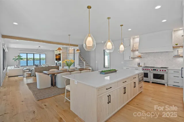a large kitchen with kitchen island a stove a sink a center island and windows