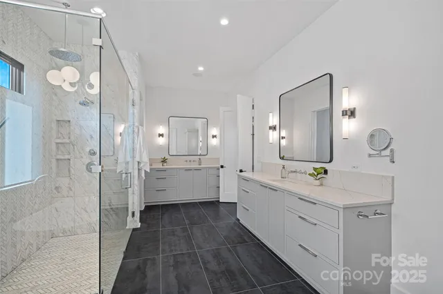 a large bathroom with a double vanity sink a toilet a mirror and shower