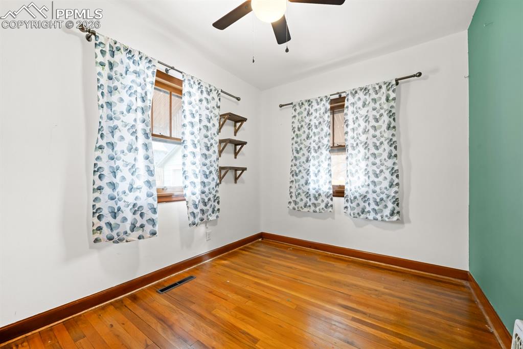 522 Madison Street Pueblo, CO 81004 - Photo 10 of 33 a view of empty room with wooden floor and fan