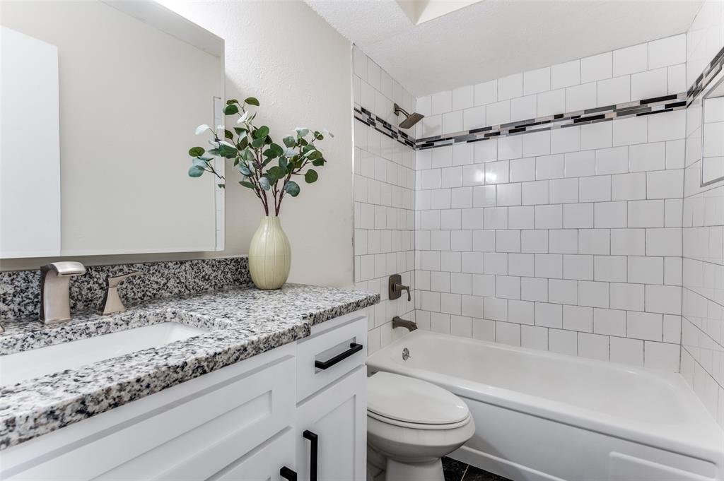 1805 Etain Road Irving, TX 75060 - Photo 18 of 23 a bathroom with a granite countertop sink a toilet and bathtub